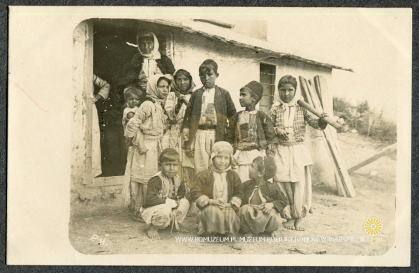 Grupa dzieci na tle domostwa