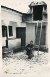 Młoda kobieta przed domostwem, mahala